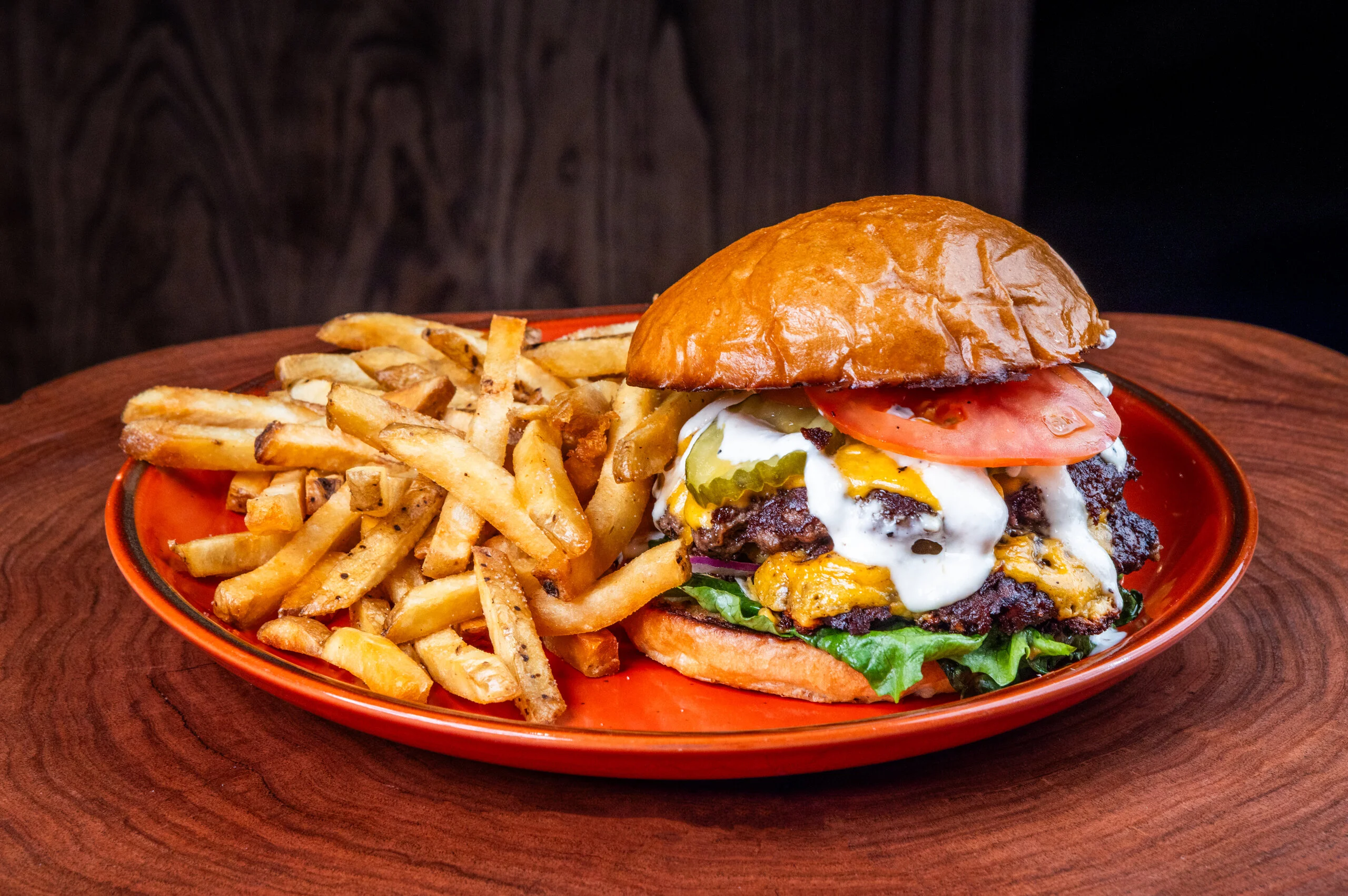 Juicy cheeseburger with fries on a wooden table