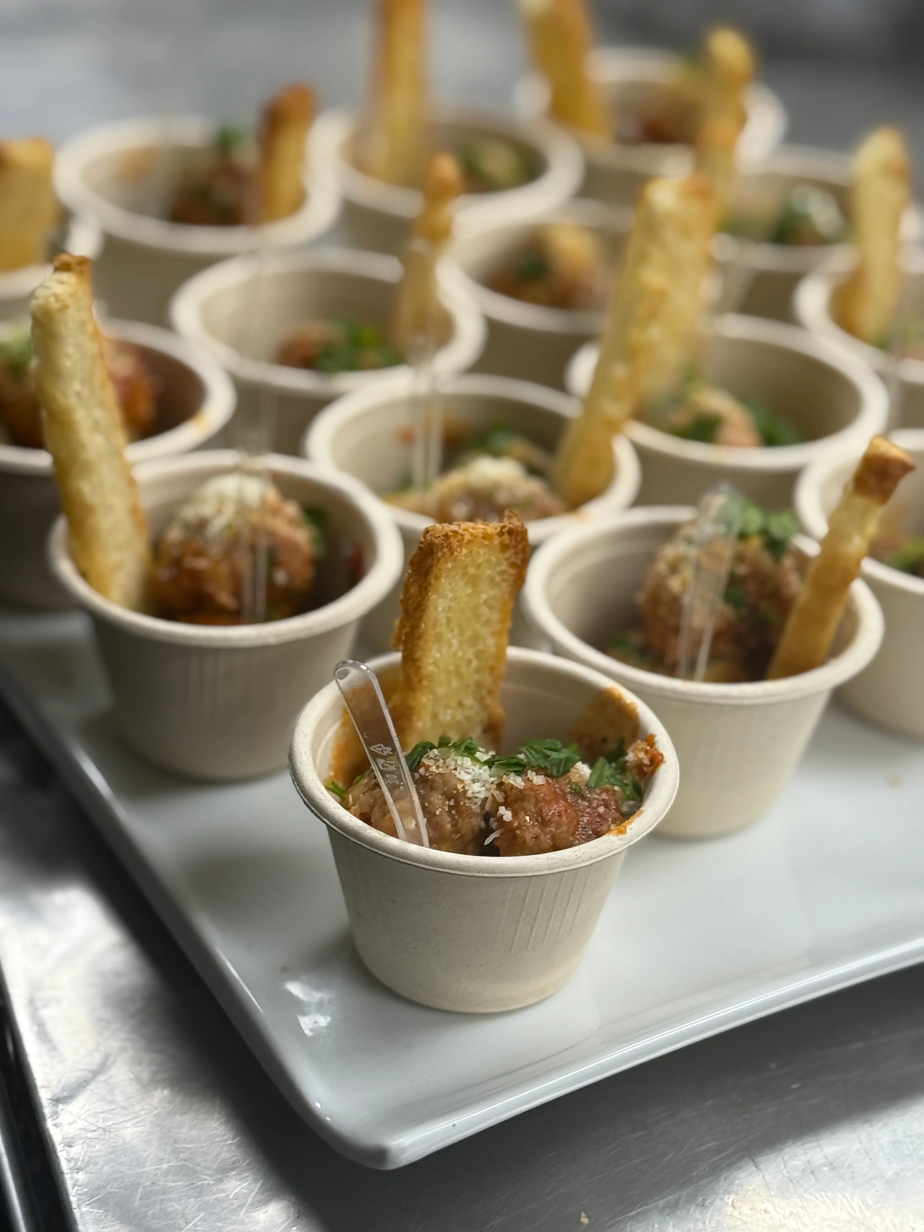 Italian meatballs served in cups with crispy breadsticks