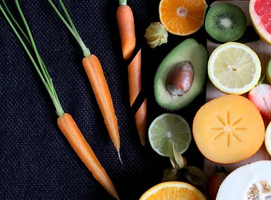 Colorful assortment of fresh fruits and vegetables on a dark background