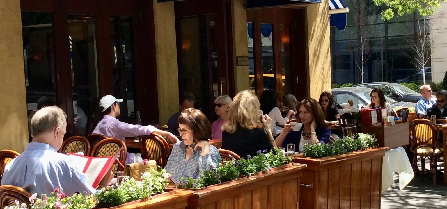 Outdoor dining area of a Mediterranean restaurant with patrons enjoying meals