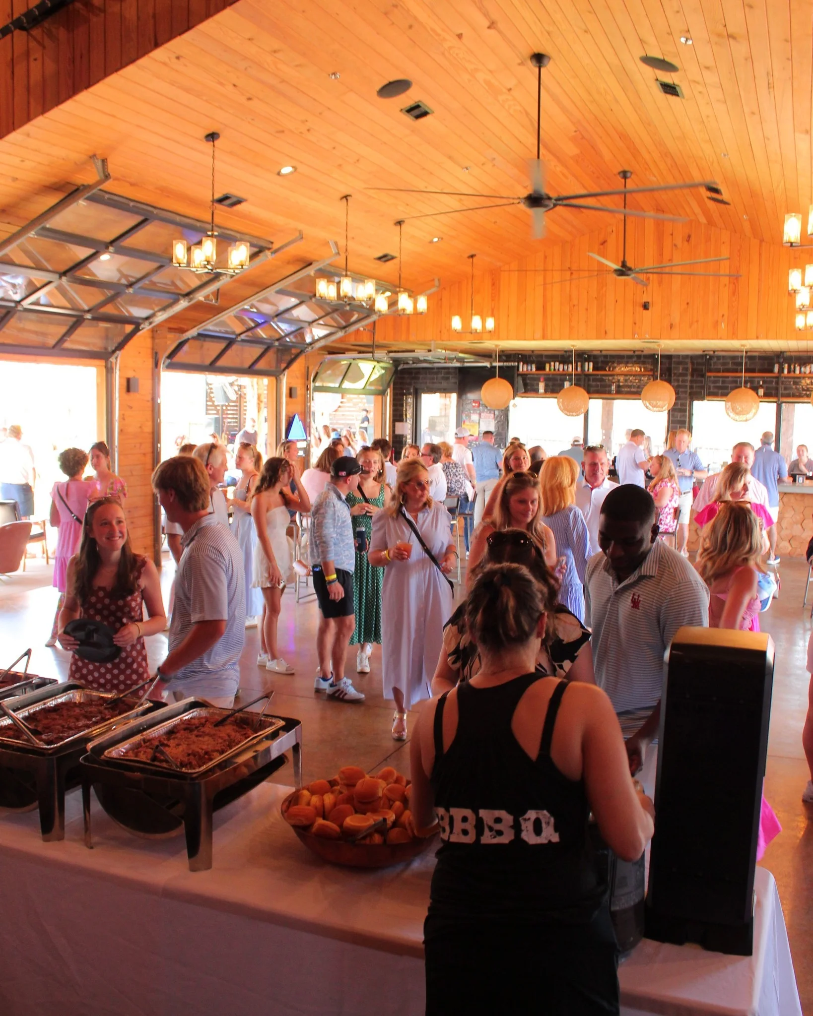 Lively restaurant interior with guests enjoying a buffet and socializing.