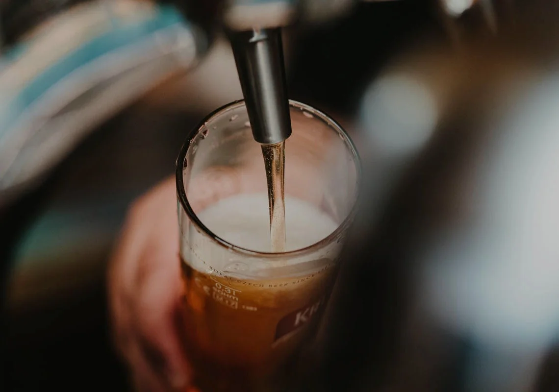 Pouring a cold beer into a glass at a bar