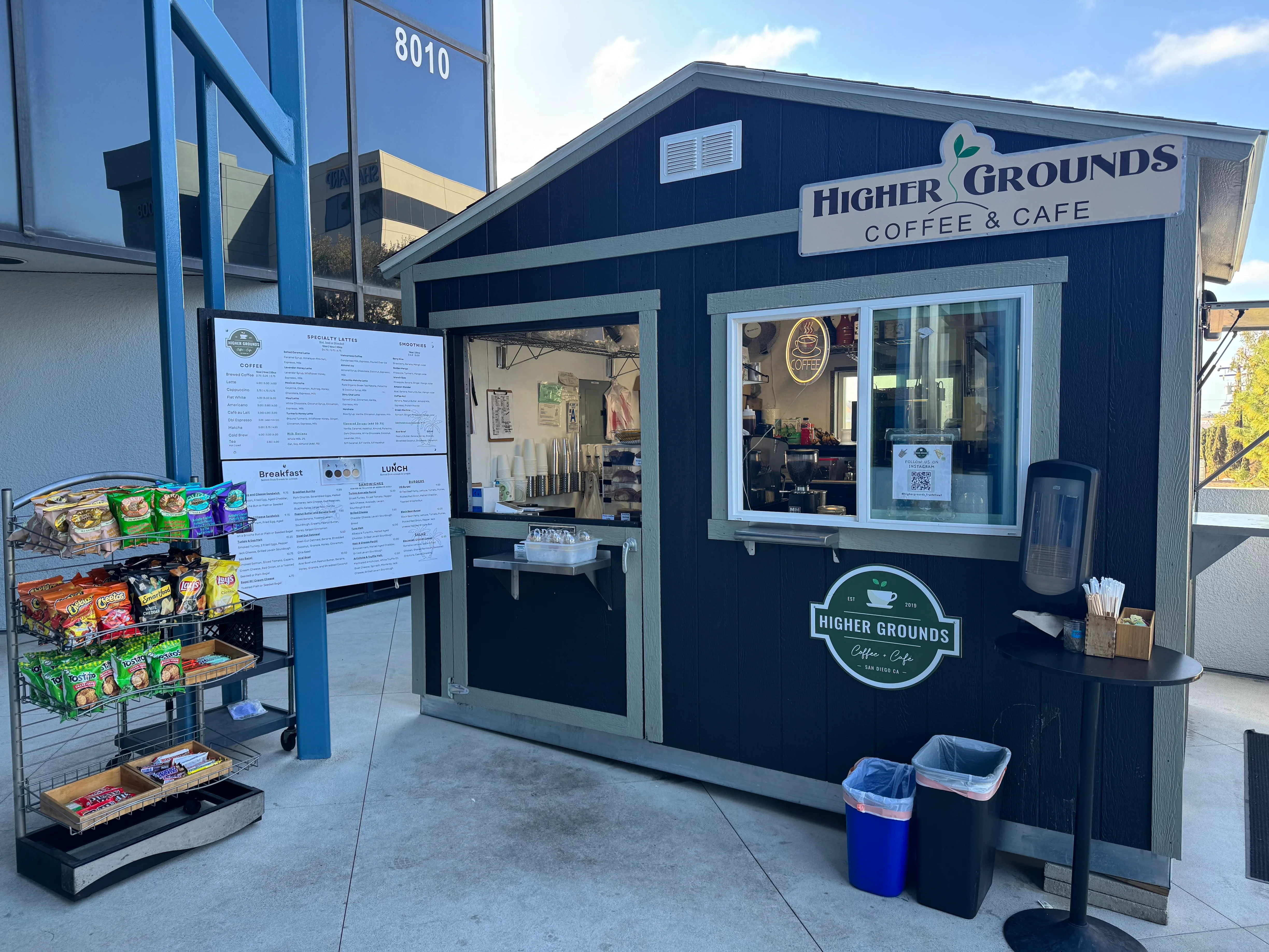 Coffee stand with menu and snacks at Higher Grounds Cafe