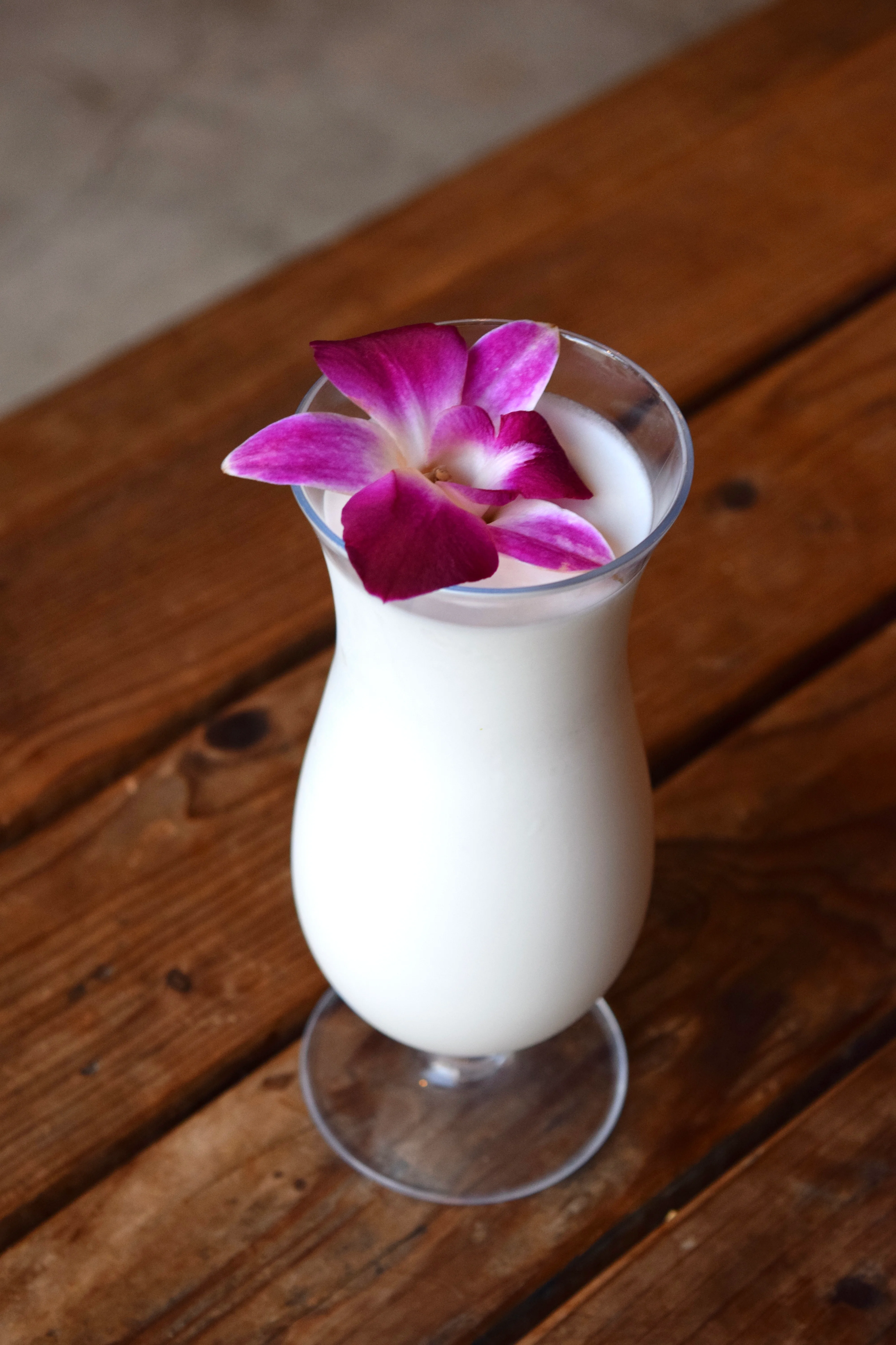 Tropical coconut cocktail garnished with orchid flower