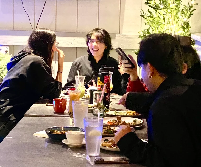 Group of friends enjoying a meal in a cozy restaurant setting