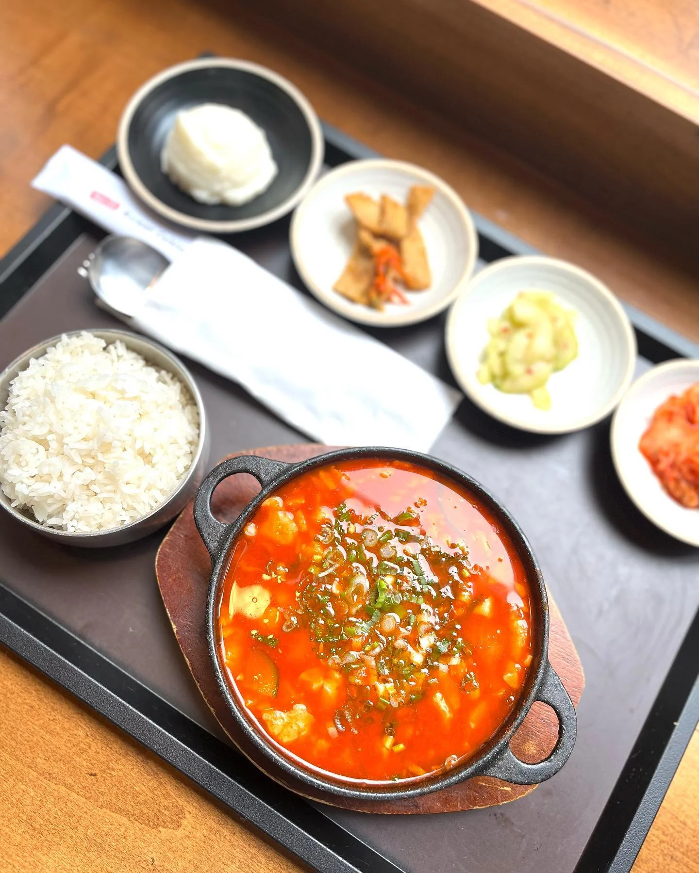 Spicy Korean jjigae stew with rice and side dishes