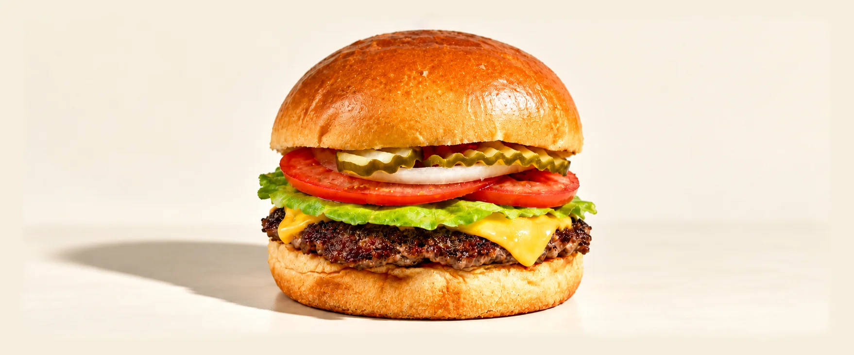 Classic American cheeseburger with lettuce, tomato, pickles, and grilled beef patty