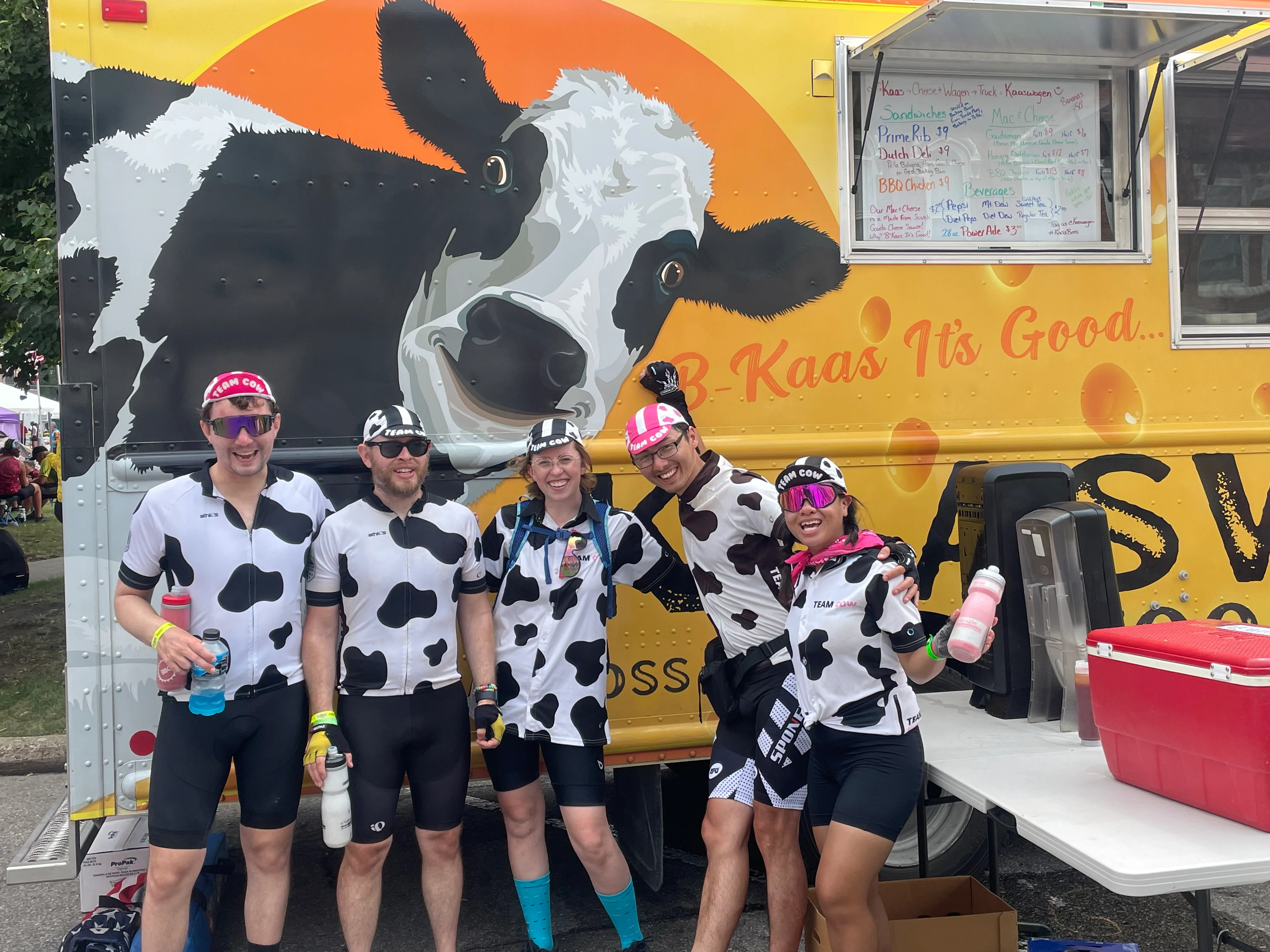 Cyclists in cow-themed outfits at a food truck event