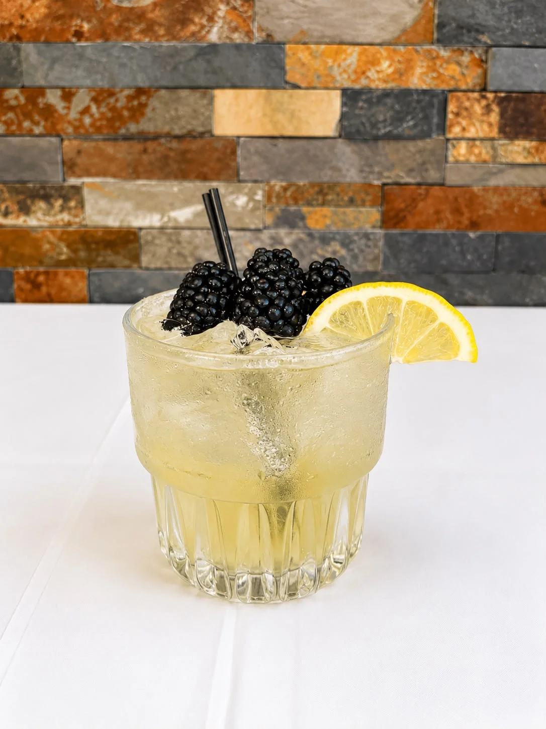Refreshing blackberry cocktail with lemon garnish