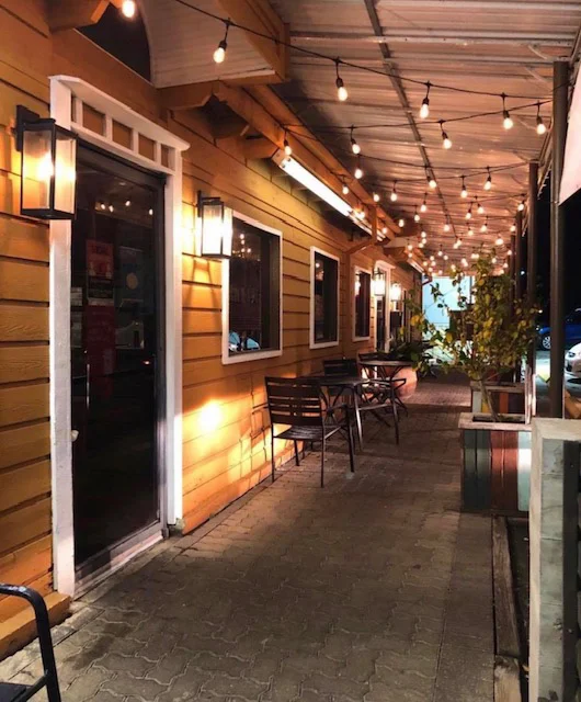Charming restaurant exterior with warm lighting and inviting seating area