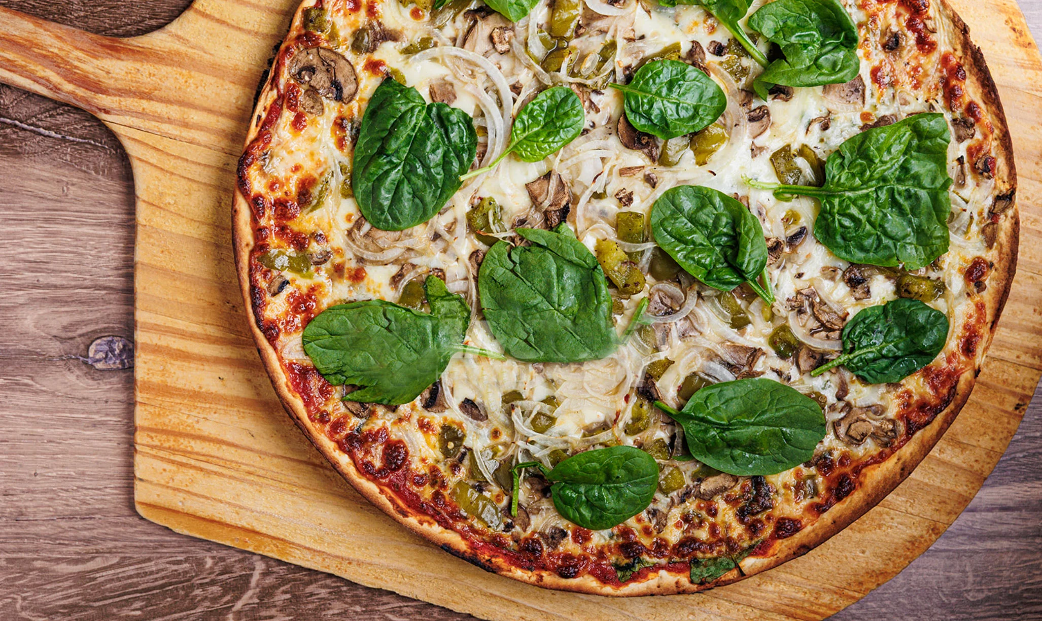 Vegetarian pizza topped with fresh spinach and mushrooms