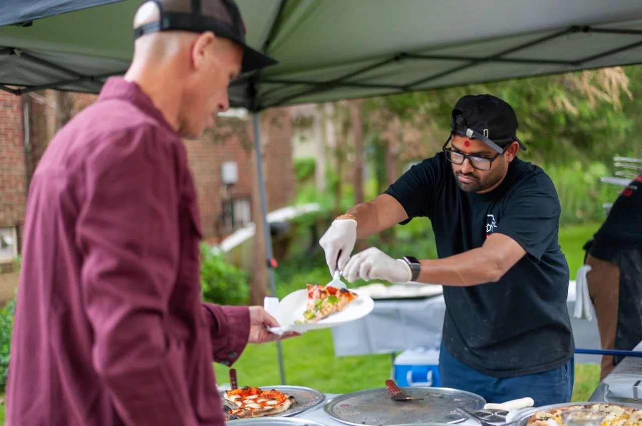 A team member handing a customer pizza