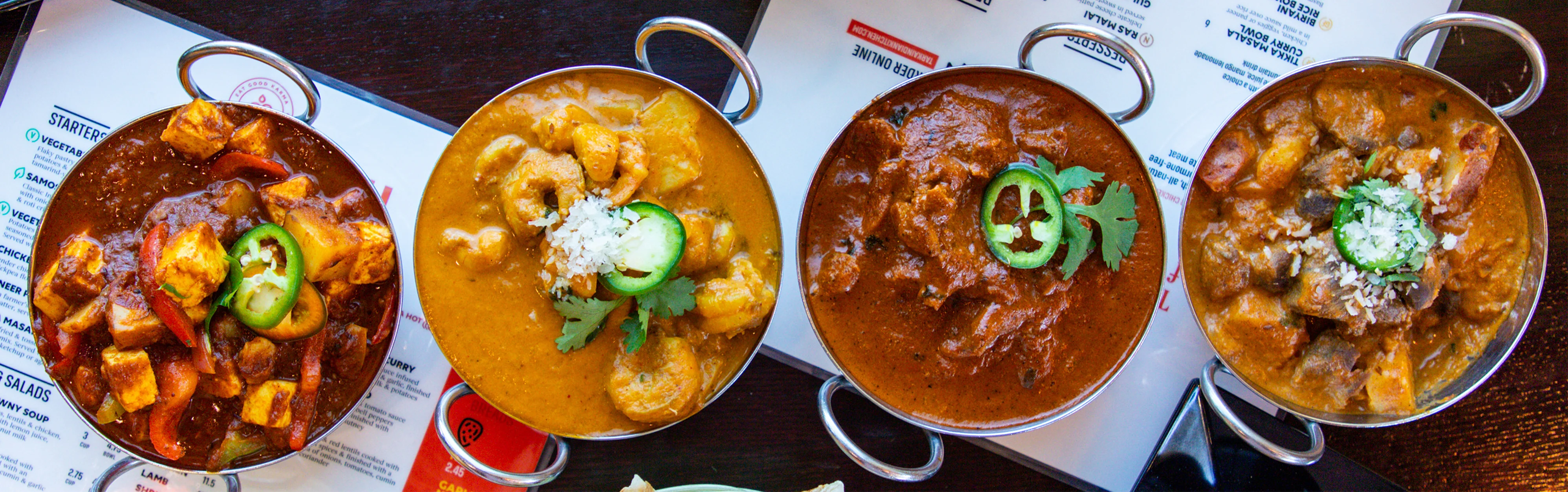 Assorted Indian curries in traditional serving bowls