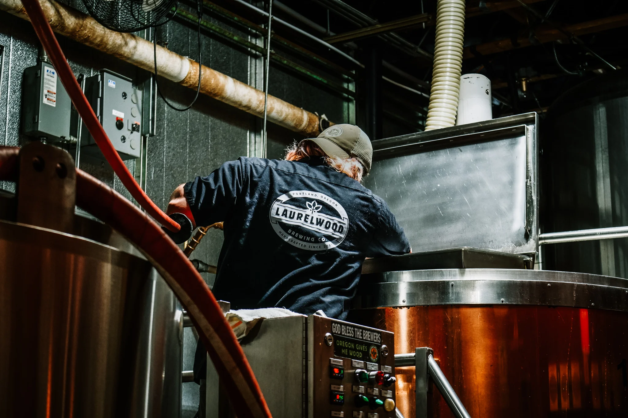 Brewery worker operating brewing equipment in a craft brewery