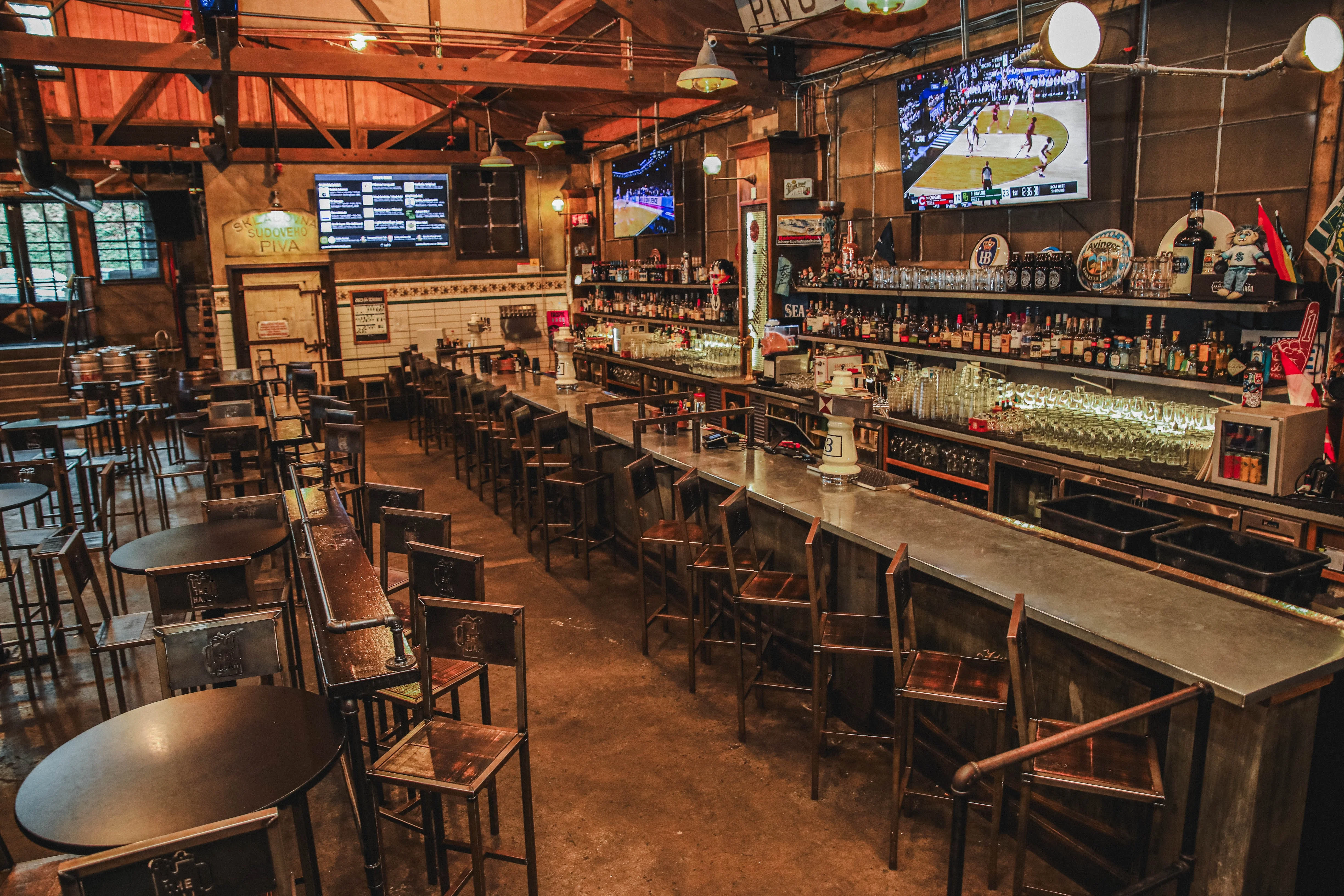 Stylish bar interior with high stools and multiple screens