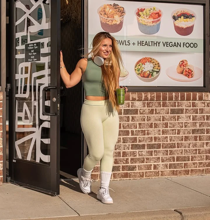 Woman enjoying a healthy vegan drink outside a restaurant