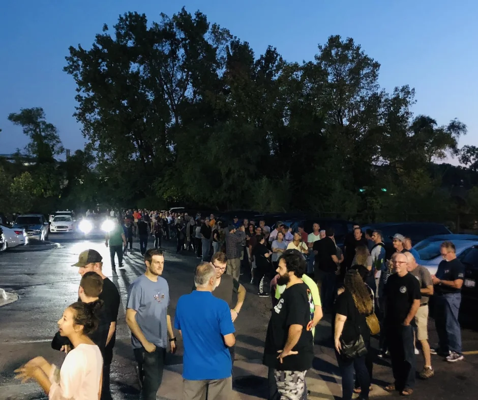 Long line of eager customers waiting outside a popular restaurant at dusk