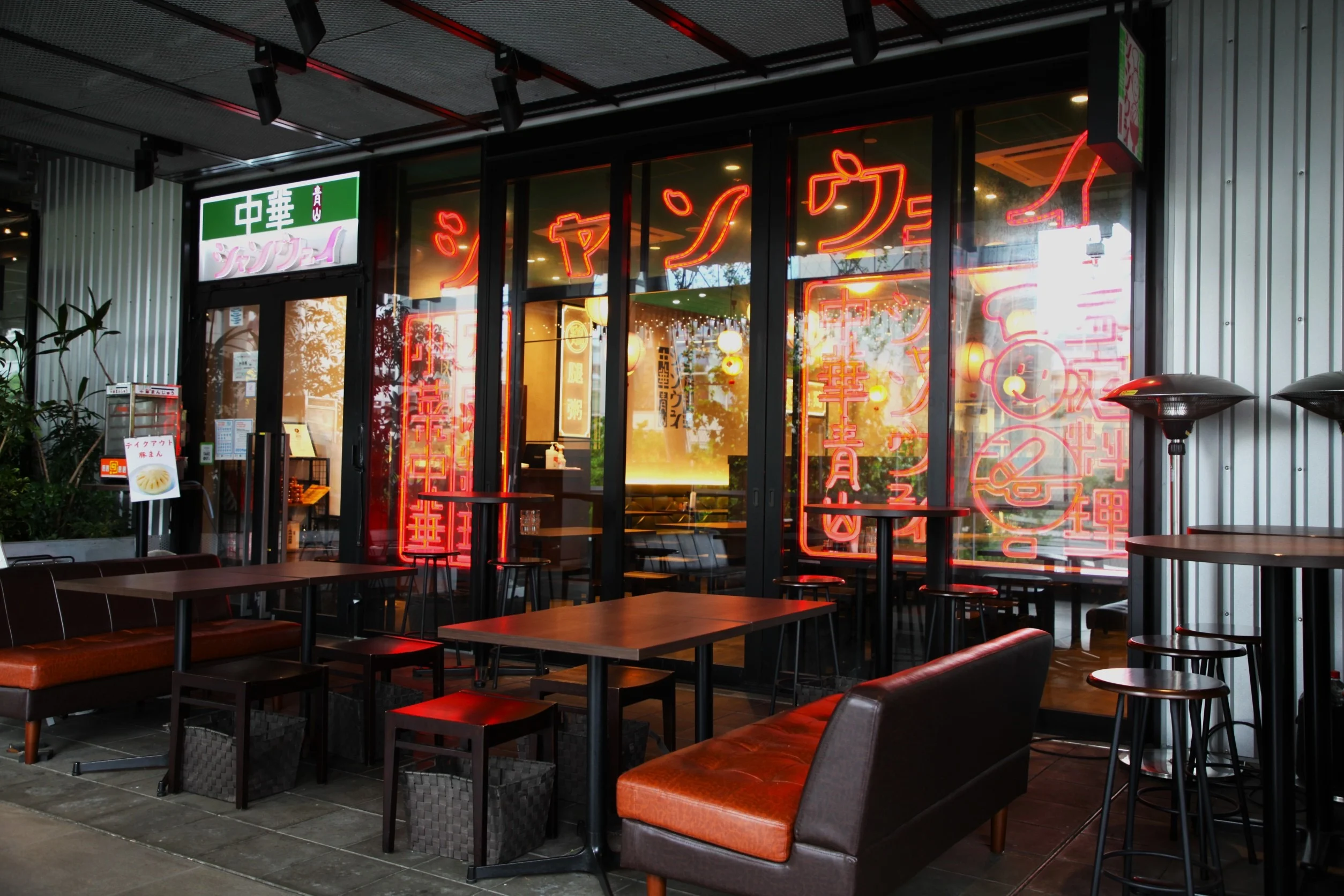 Cozy restaurant exterior with neon signs and outdoor seating
