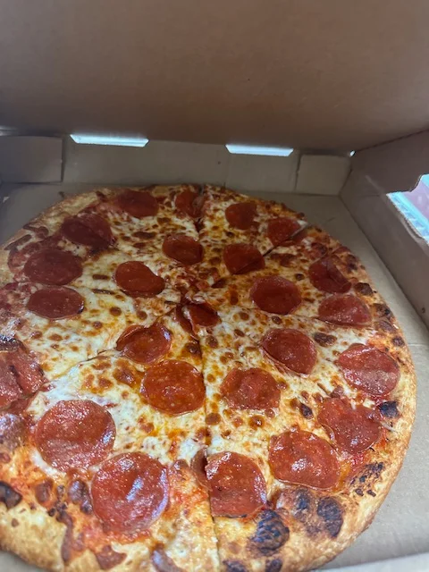 Classic pepperoni pizza in a takeout box