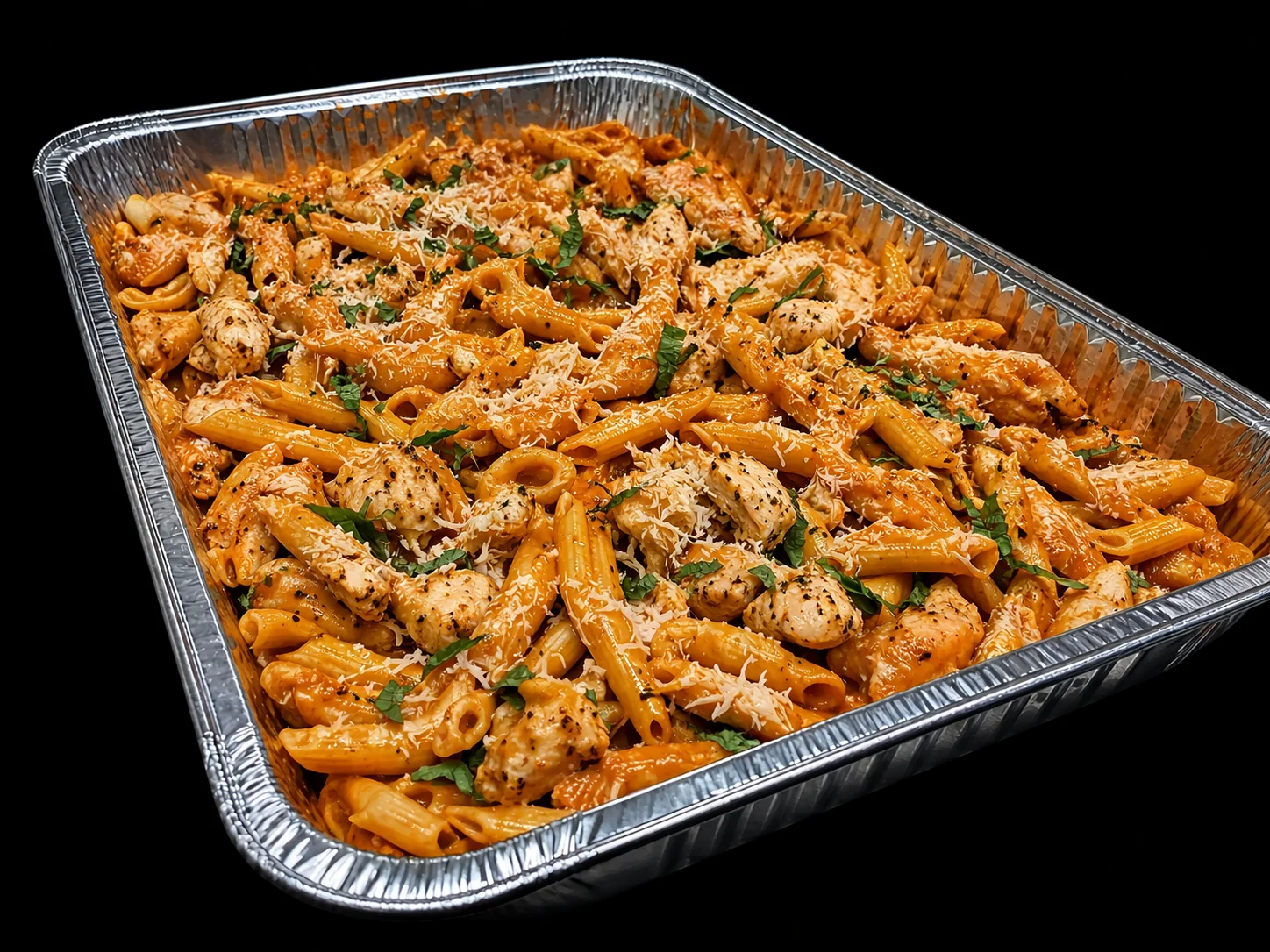 Creamy chicken penne pasta bake in a catering tray