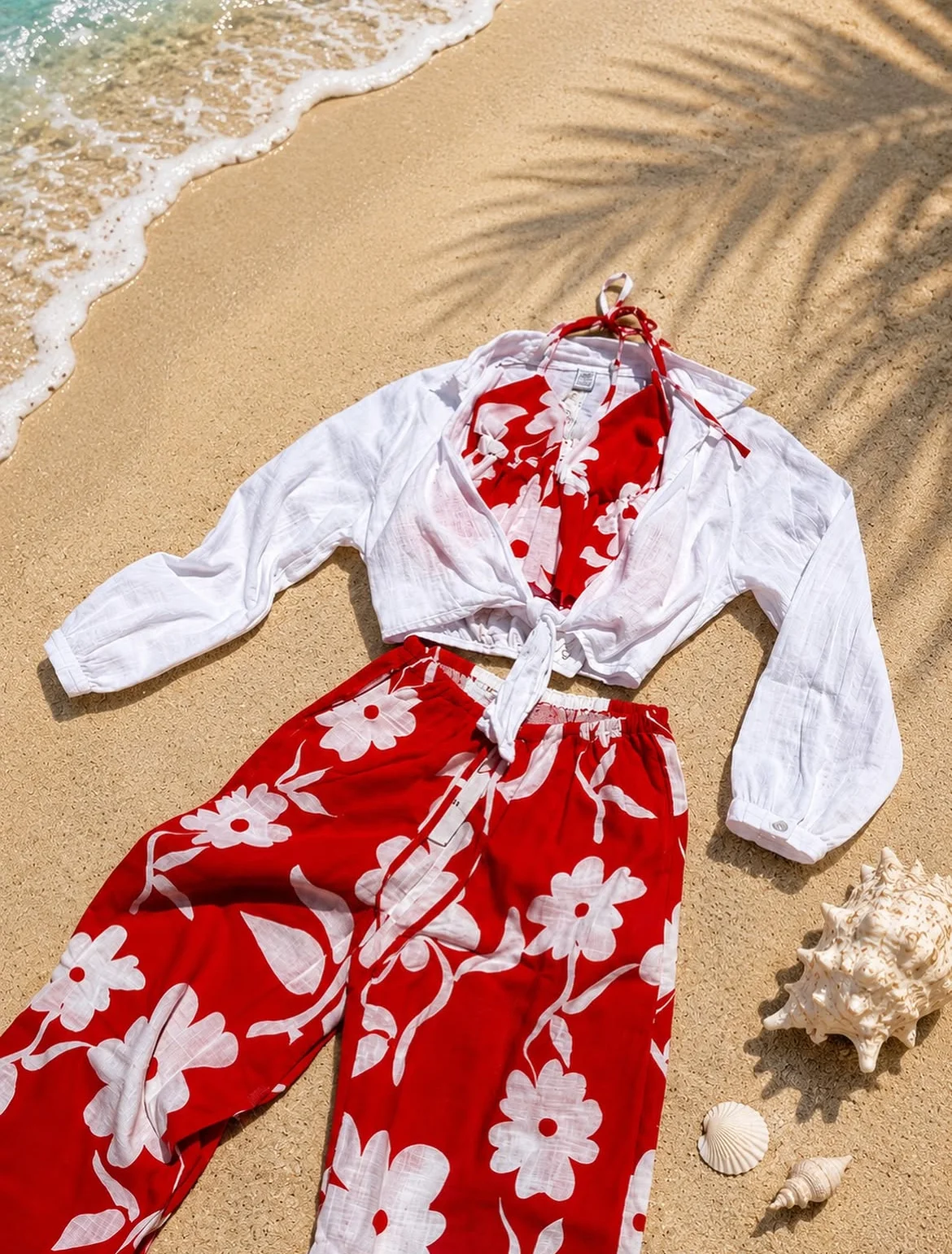 Matching top and pant sent with a white cover up laying on the sand