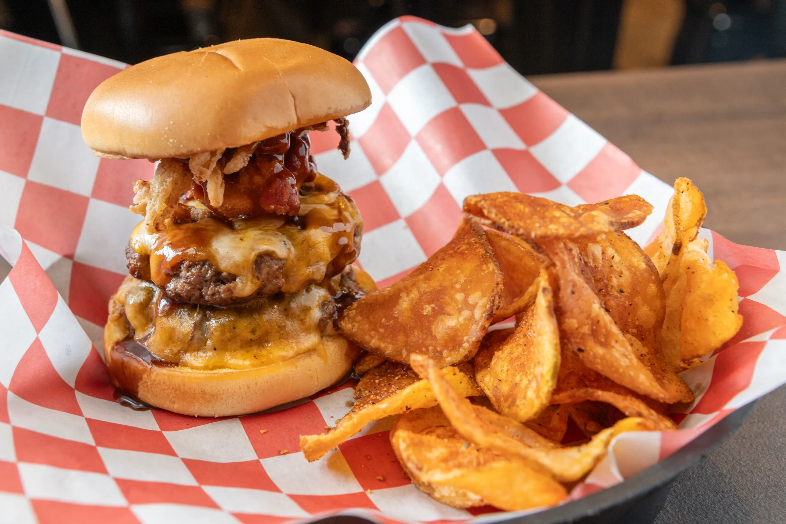 Juicy cheeseburger with crispy chips in a basket