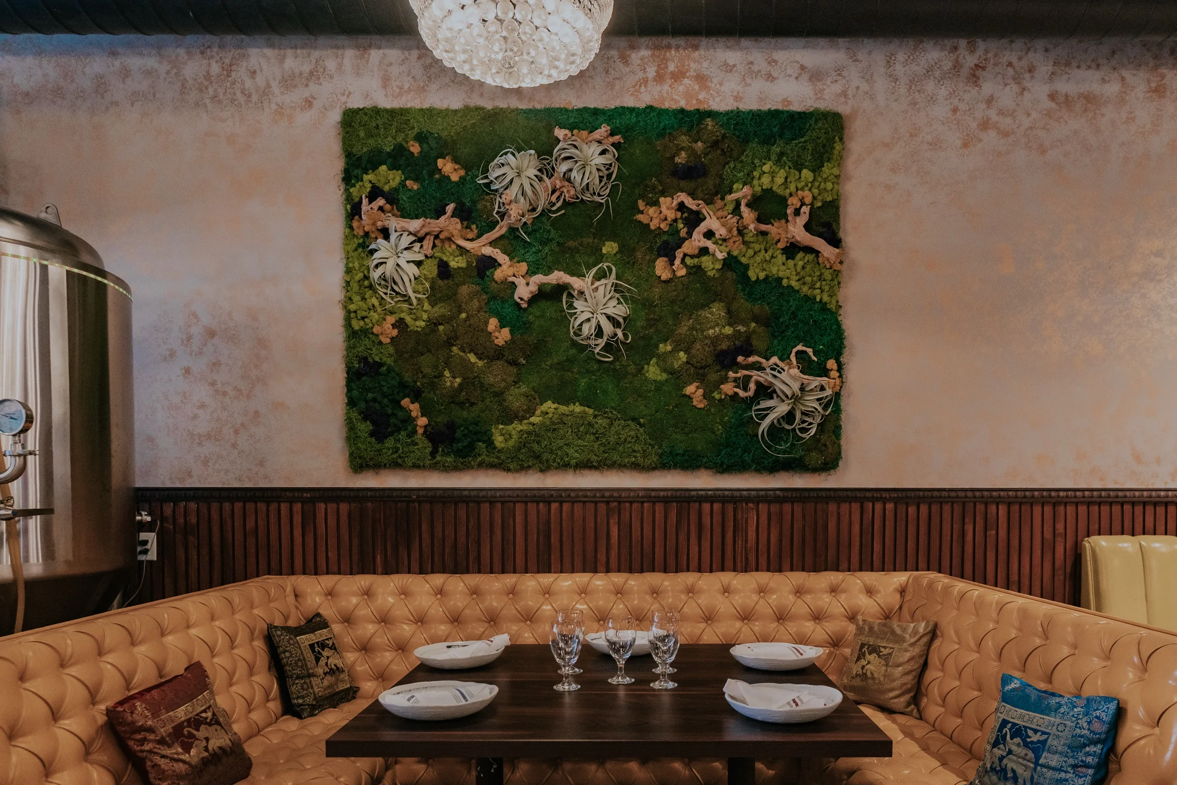 Tufted lounge seating and moss wall art at Castro Indian Restaurant