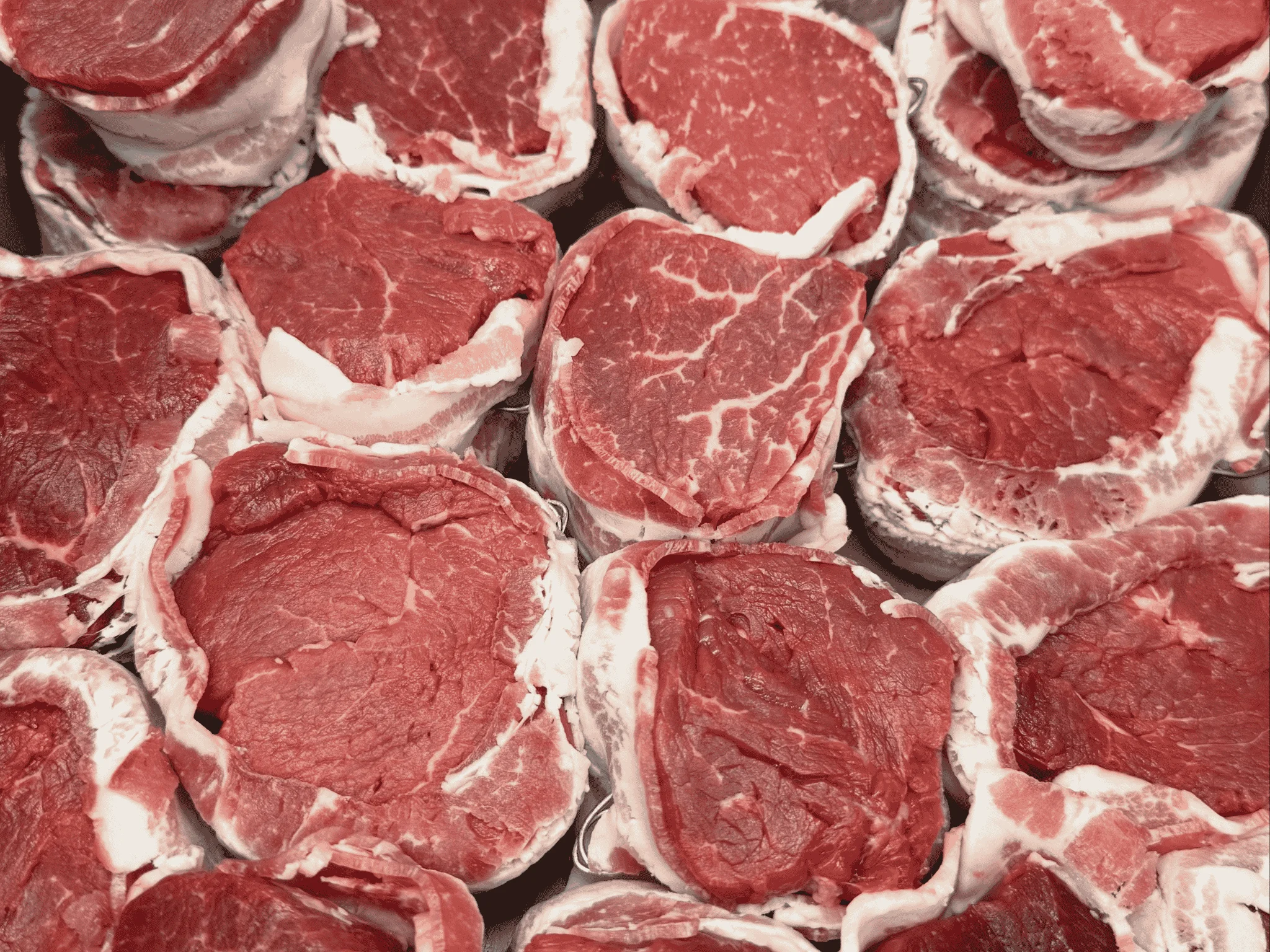 Close-up of fresh cuts of red meat arranged in a display.