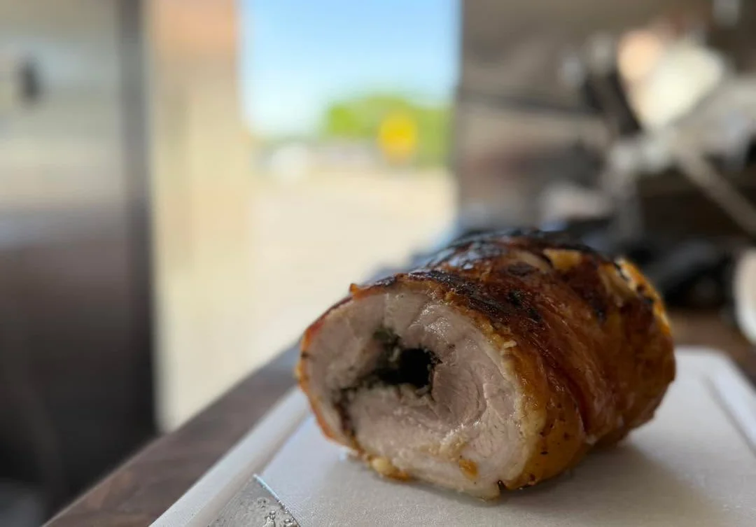 Sliced porchetta with crispy skin and herbs