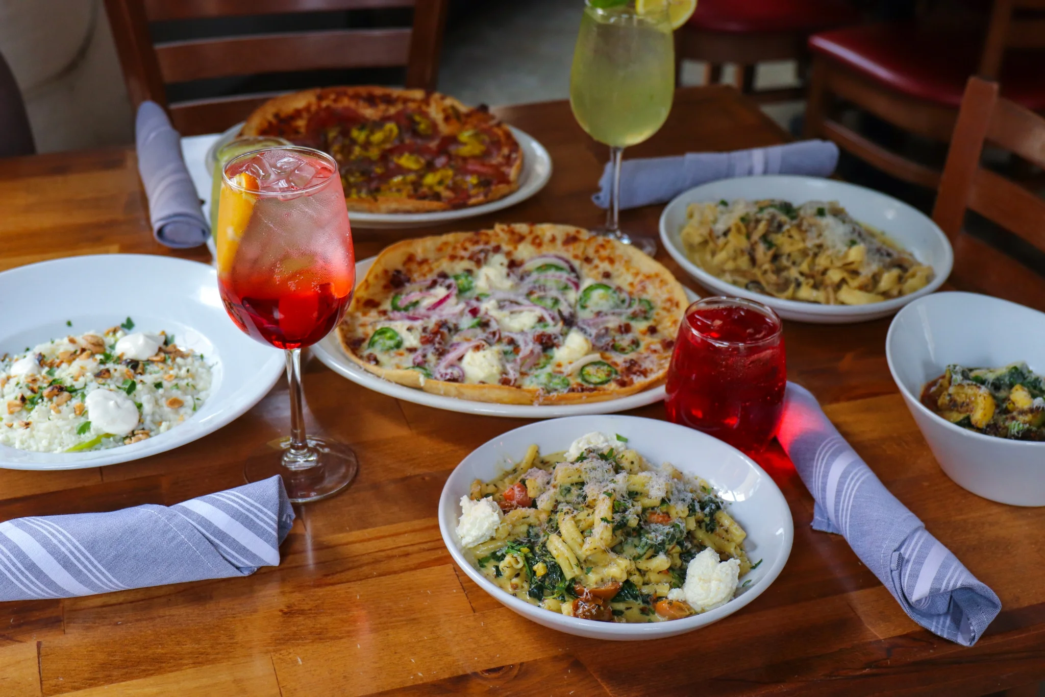 Italian pasta dishes and pizza on a wooden table