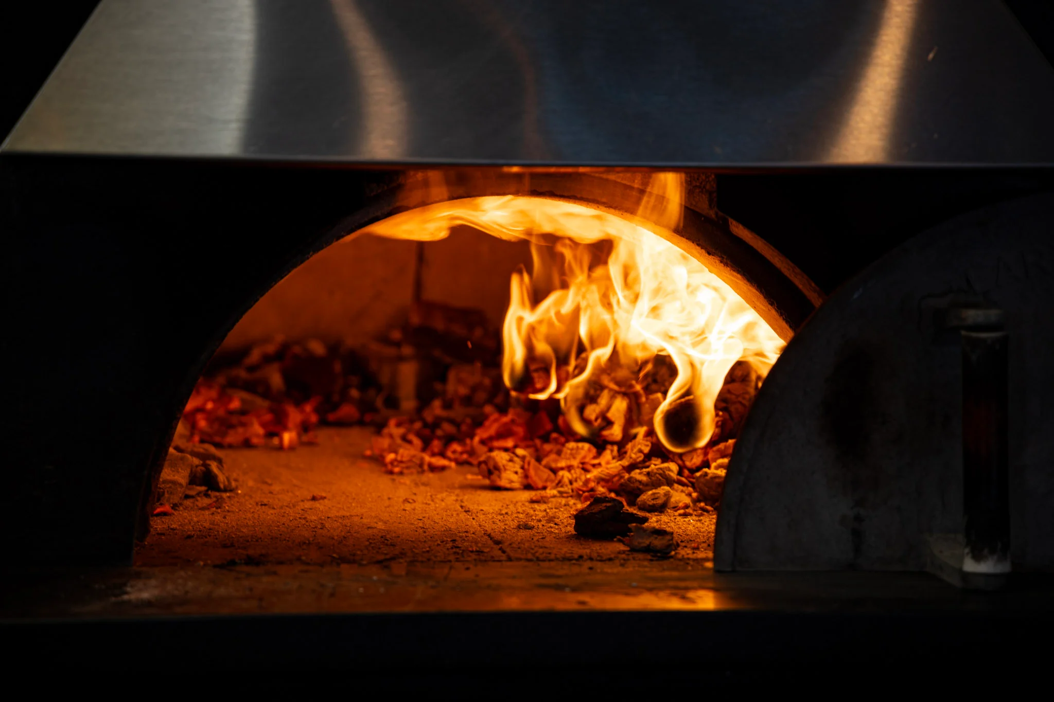 Flames dancing in a wood-fired pizza oven