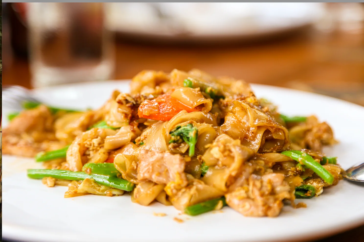 Plate of Thai pad see ew with wide rice noodles and vegetables