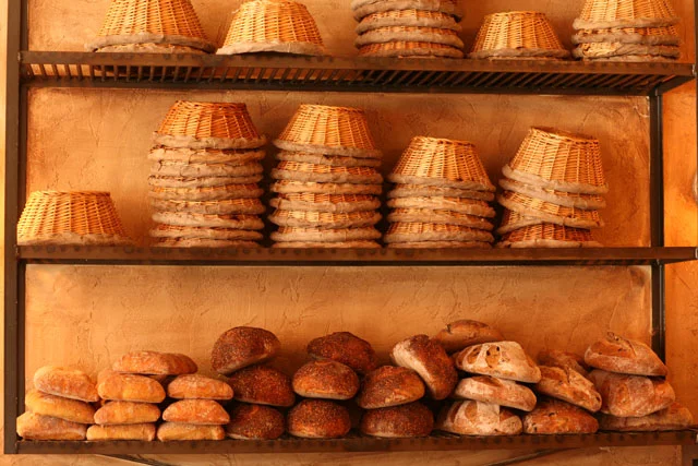 Artisan bread displayed on rustic shelves in a bakery