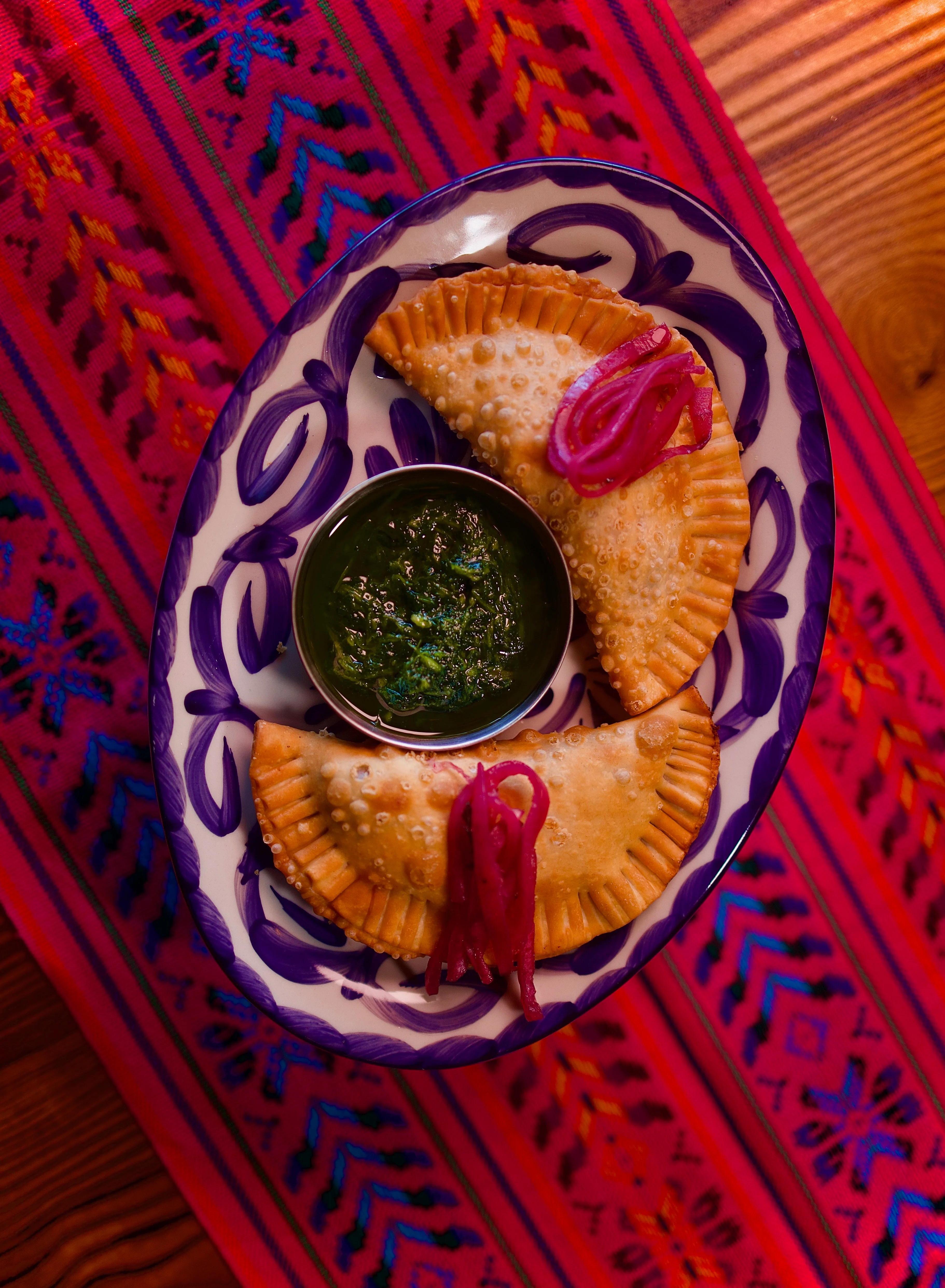 Crispy empanadas with green chutney and pickled onions