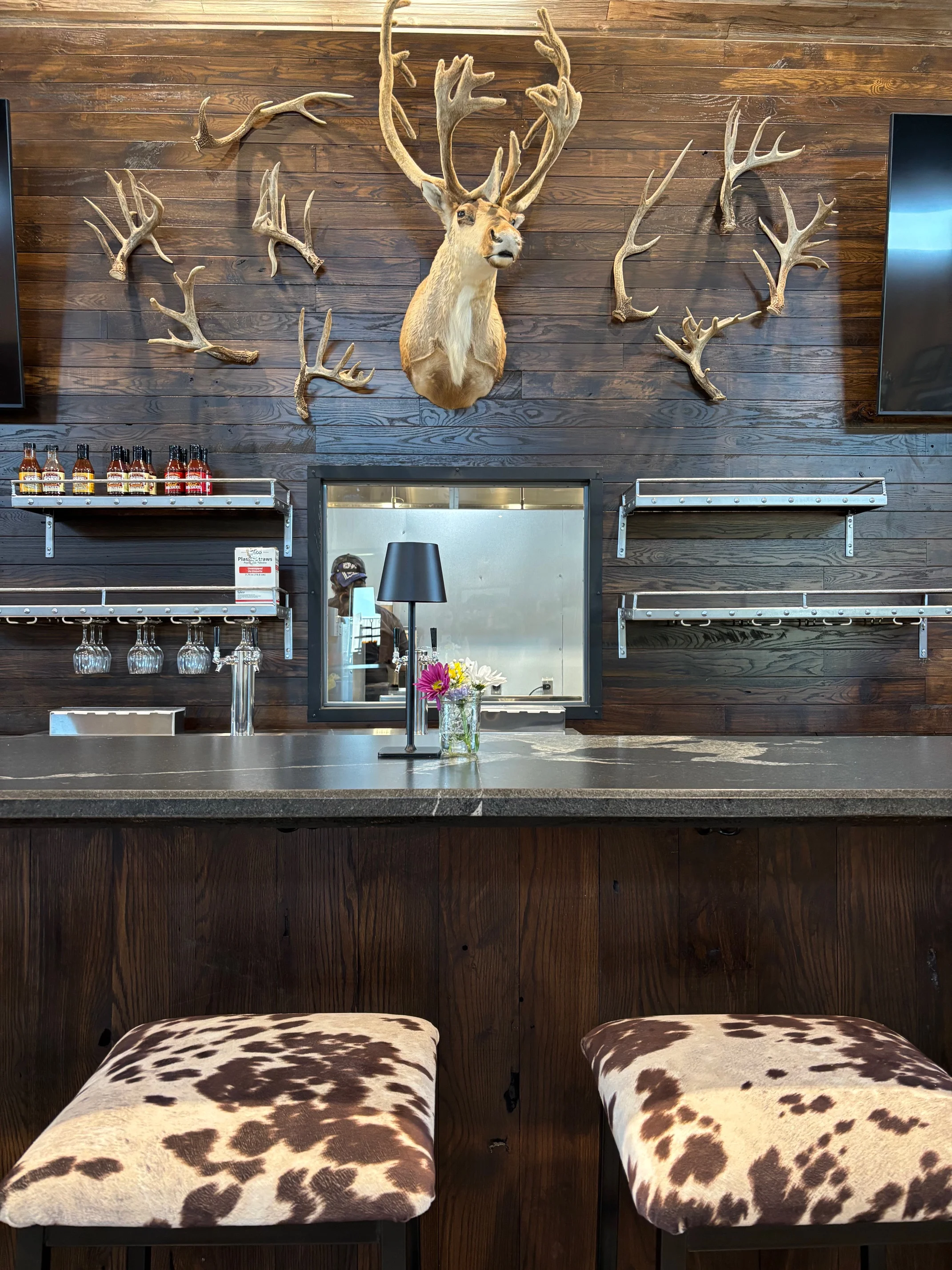 Rustic bar interior with antler decor and cowhide stools