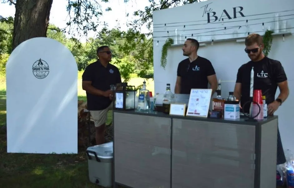 Bartenders serving drinks at an outdoor bar