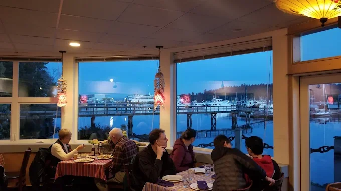 Cozy restaurant interior with waterfront view at dusk