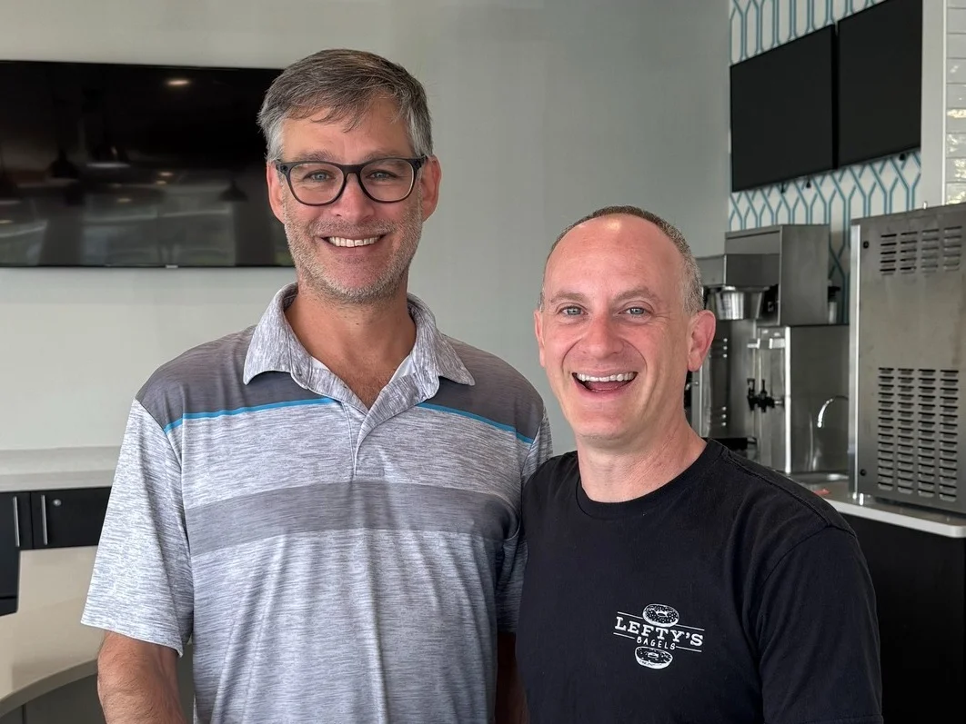 Two restaurant owners smiling in a modern dining space
