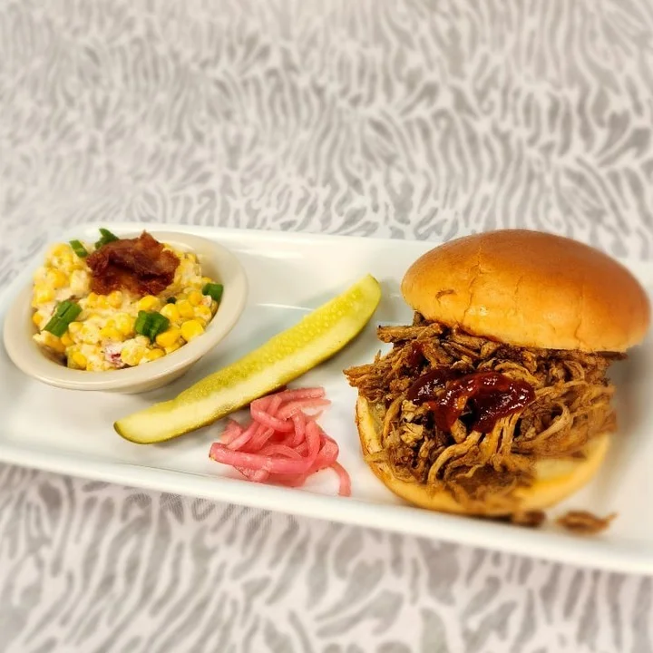 Pulled pork sandwich with sides in a casual dining setting