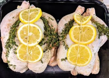 Whole fried chicken on a platter, garnished and ready to serve.