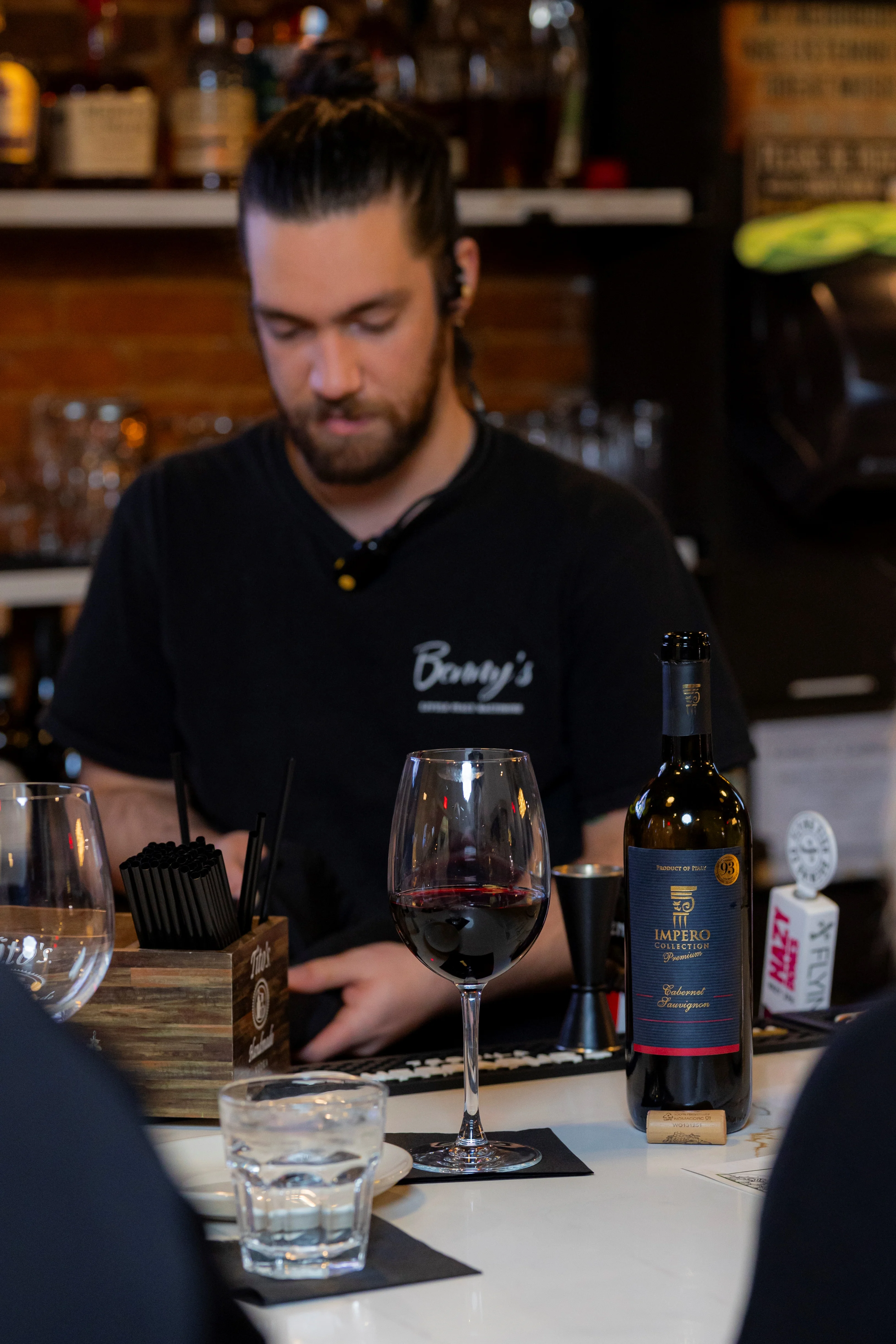 Bartender serving red wine at a stylish bar