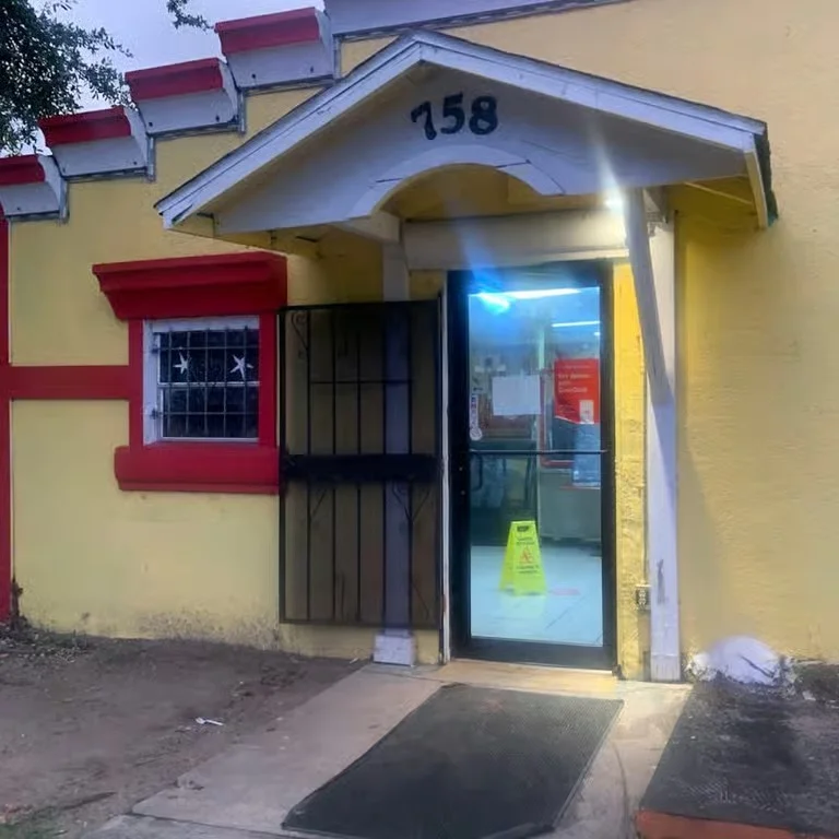 Entrance of a restaurant with a yellow exterior and a visible sign.