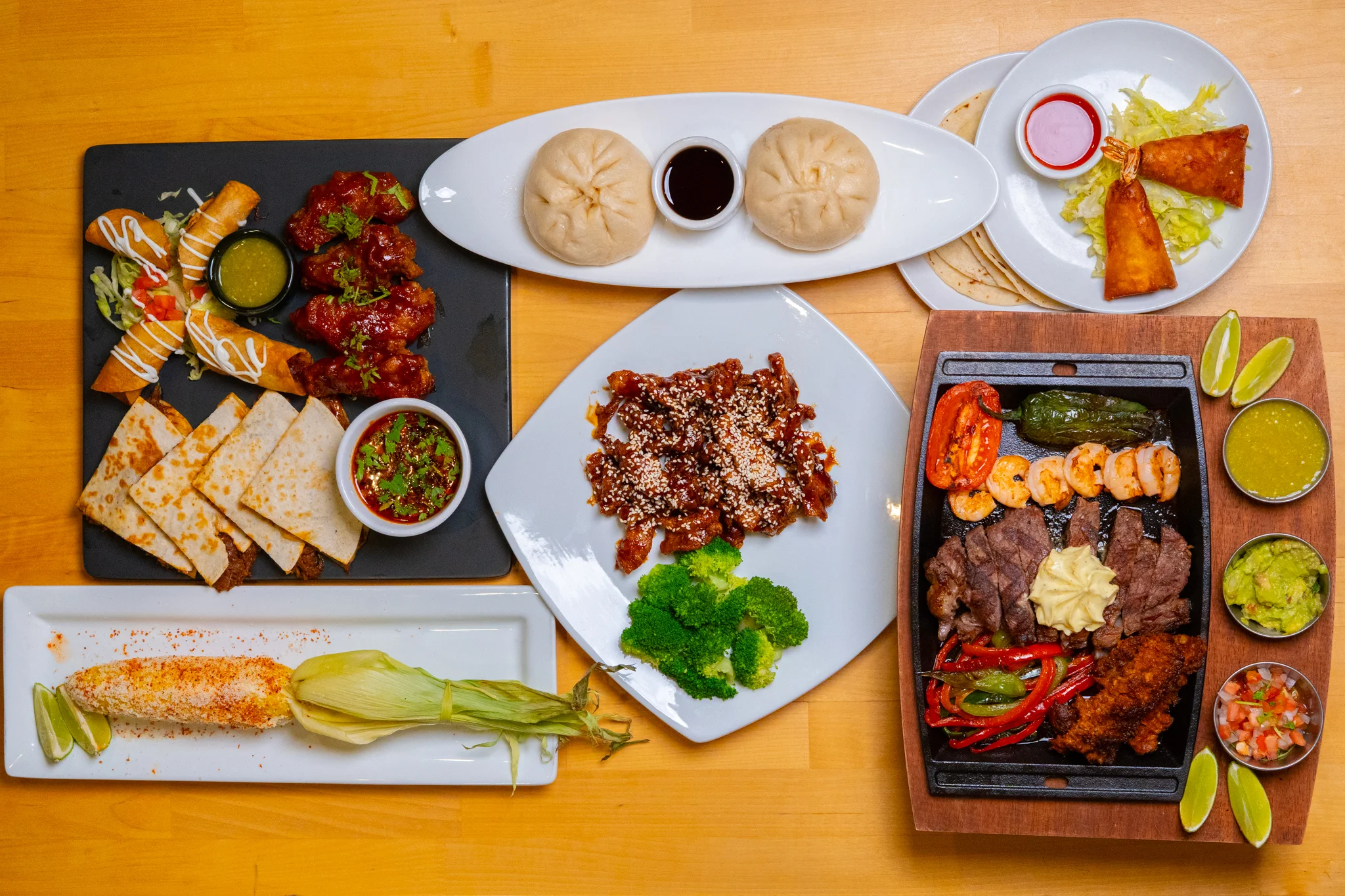 Assorted Mexican and Asian fusion dishes on a wooden table