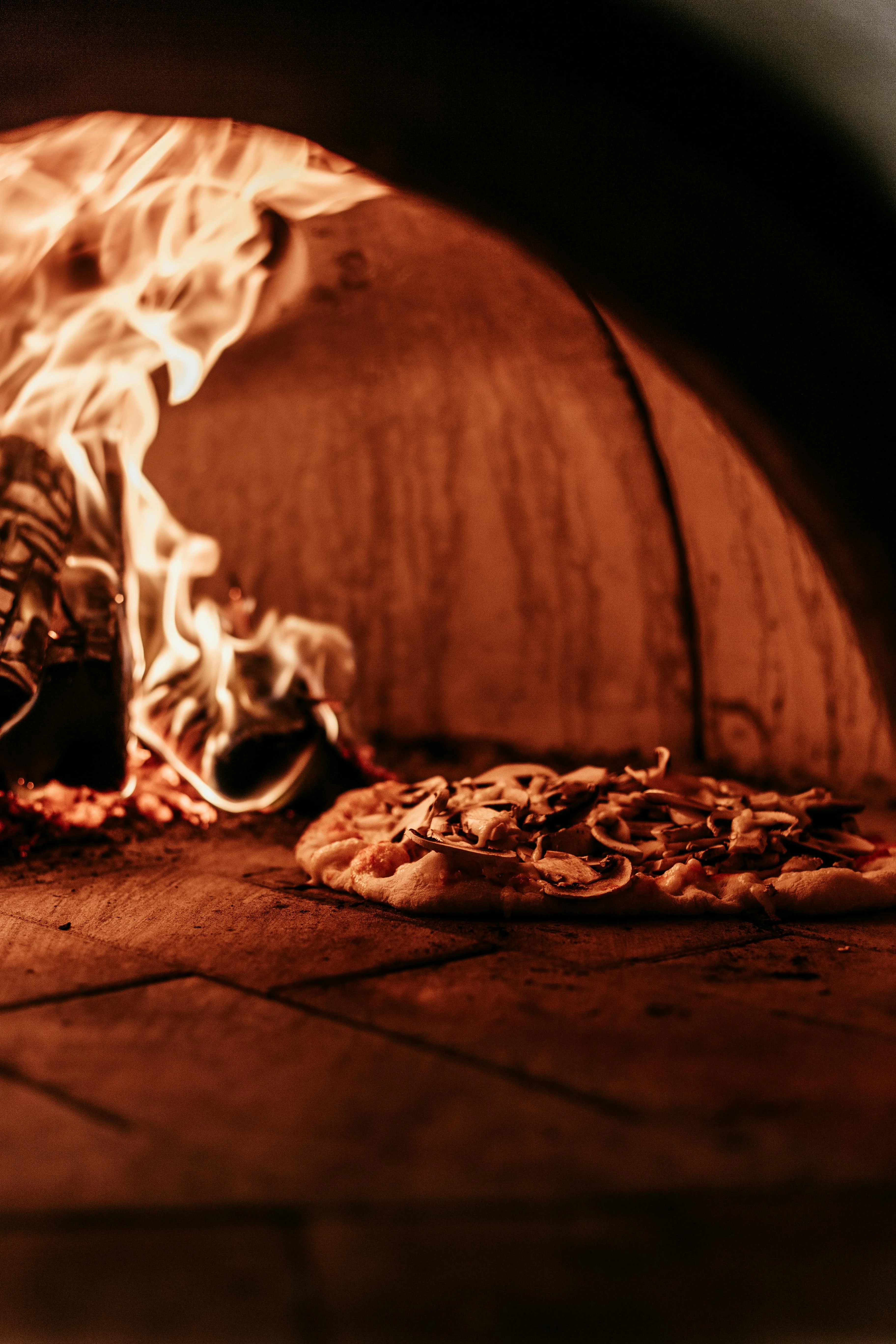 Wood-fired Margherita pizza baking in a traditional oven