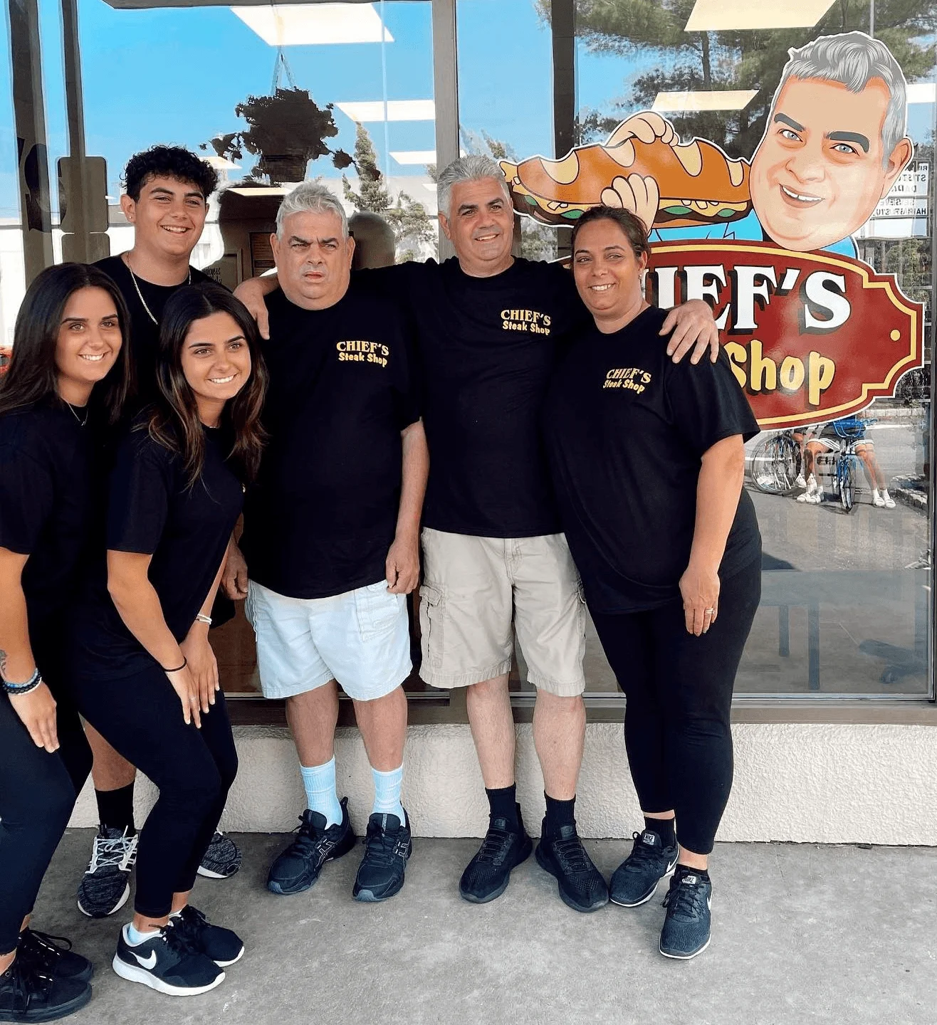 Team at Chief's Steak Shop posing outside their restaurant