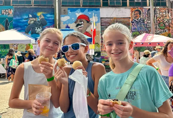 Friends enjoying snacks at a vibrant street food festival