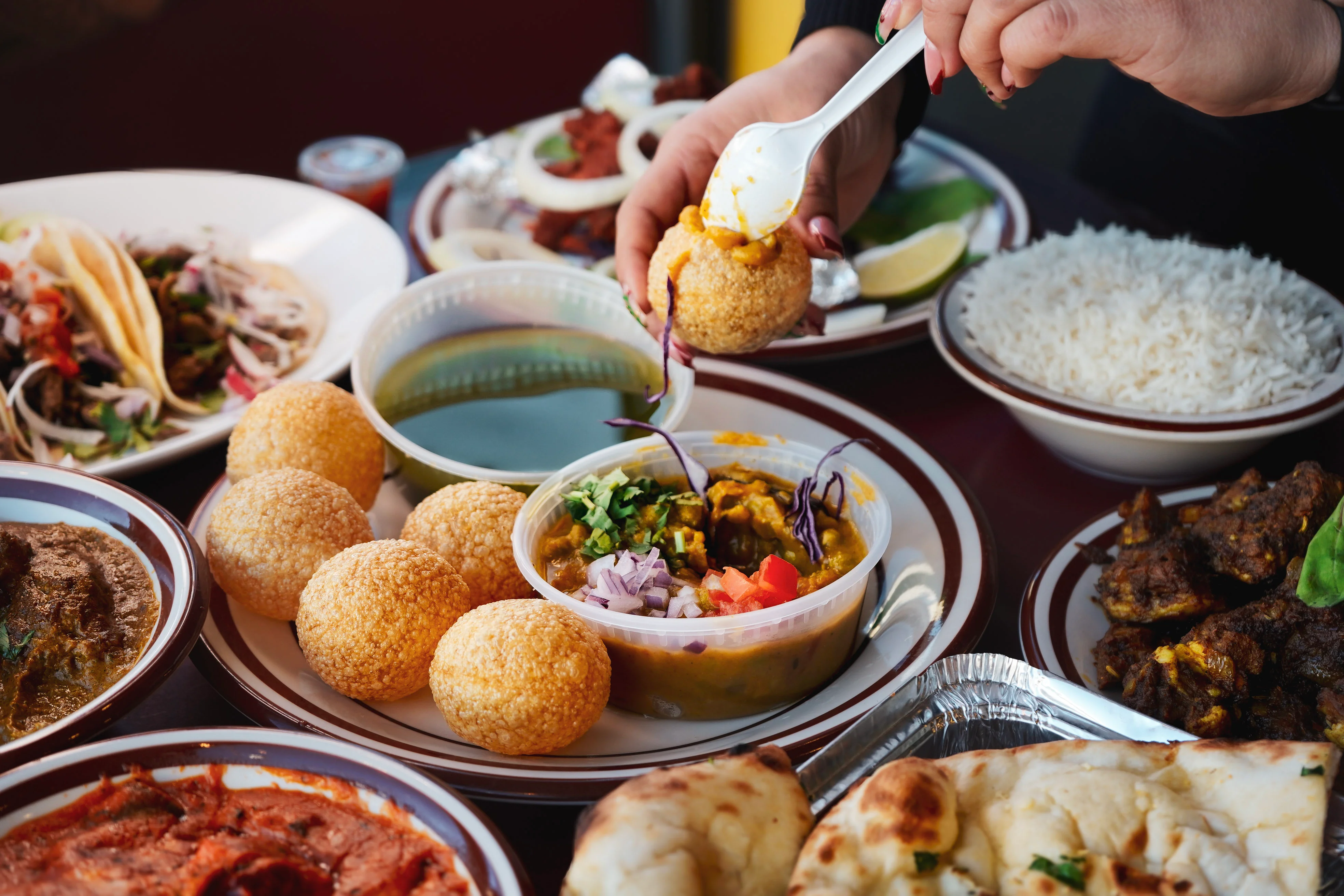 Indian pani puri served with spicy chutney and garnishes