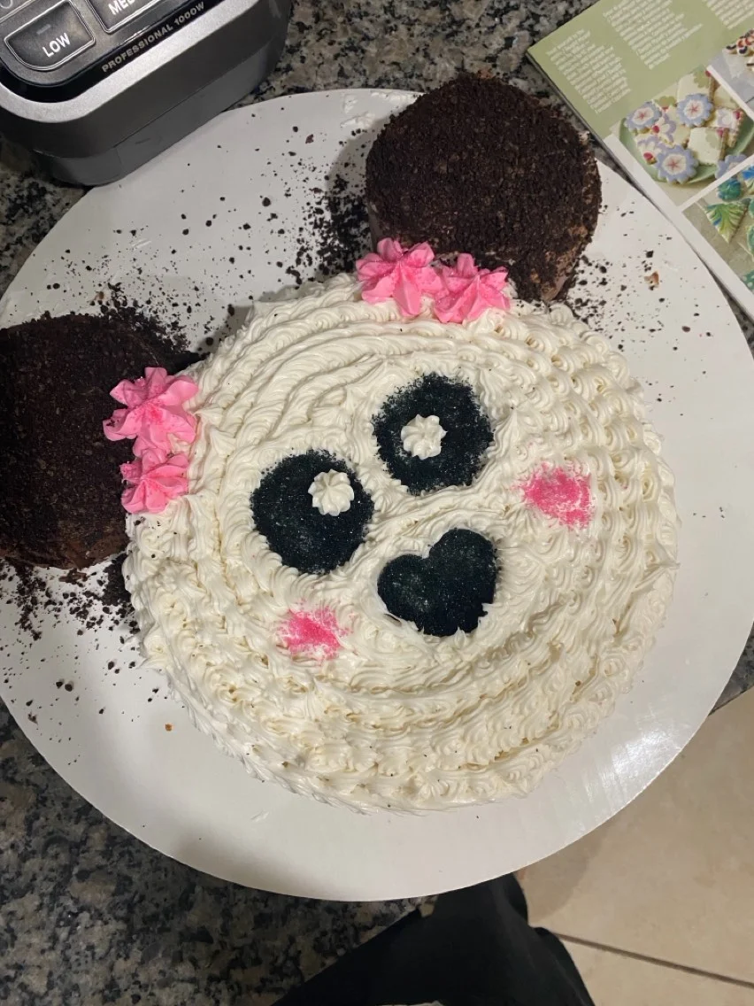 Cute panda-themed cake decorated with frosting and chocolate accents
