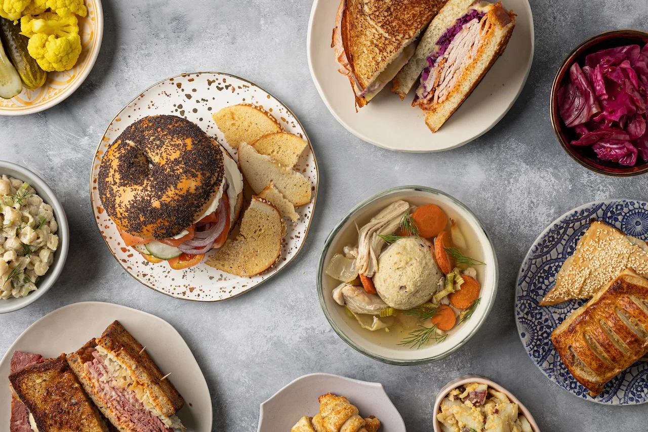 Assorted deli sandwiches and chicken soup in a cozy setting