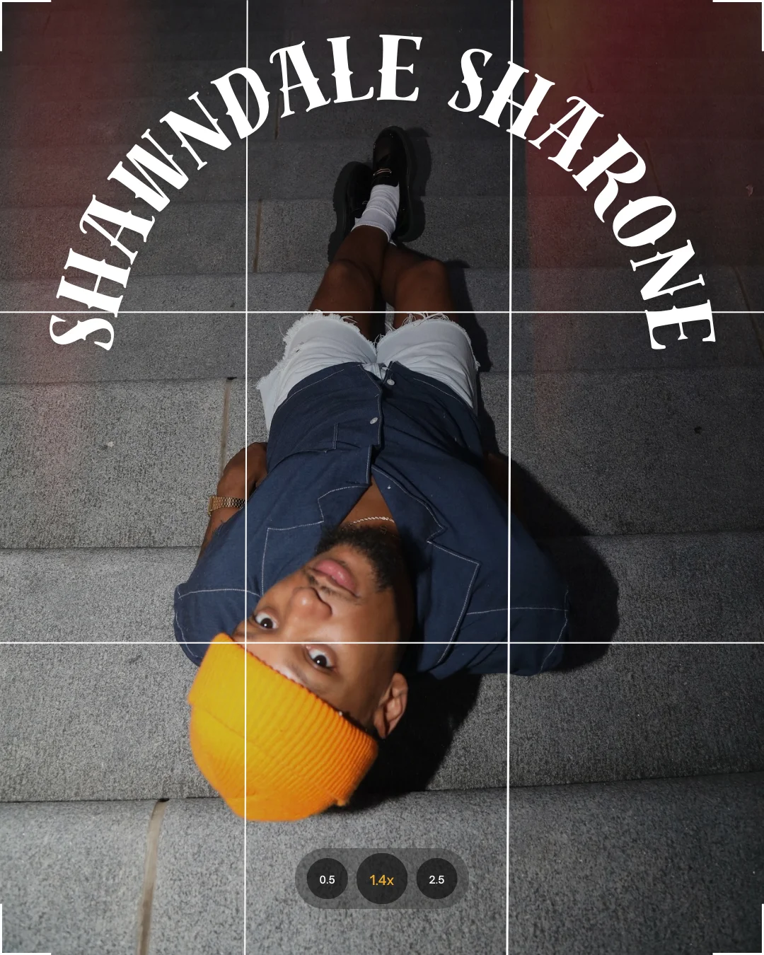 Person lying on stairs wearing an orange beanie and denim outfit